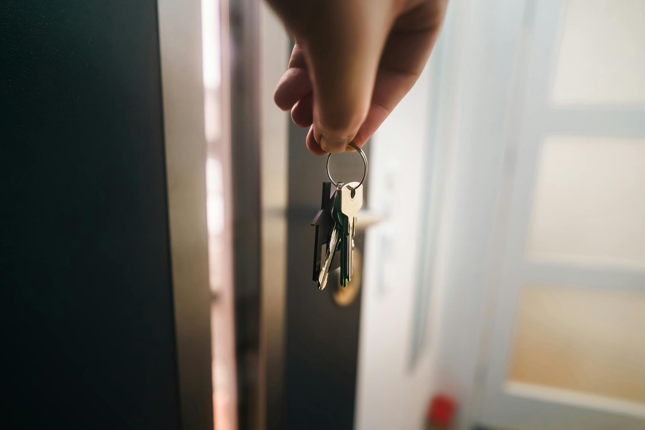 Close-up of a hand holding keys, symbolizing home ownership or rental entry.